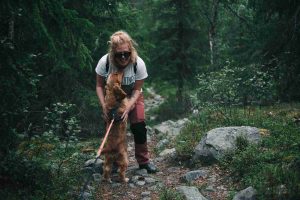 A dog with her owner while hiking on the woods