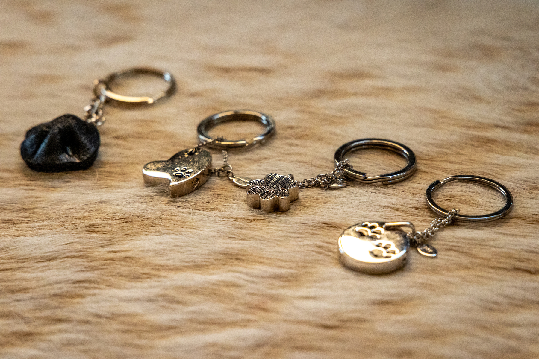 A collection of four key chains, each adorned with unique decorative charms