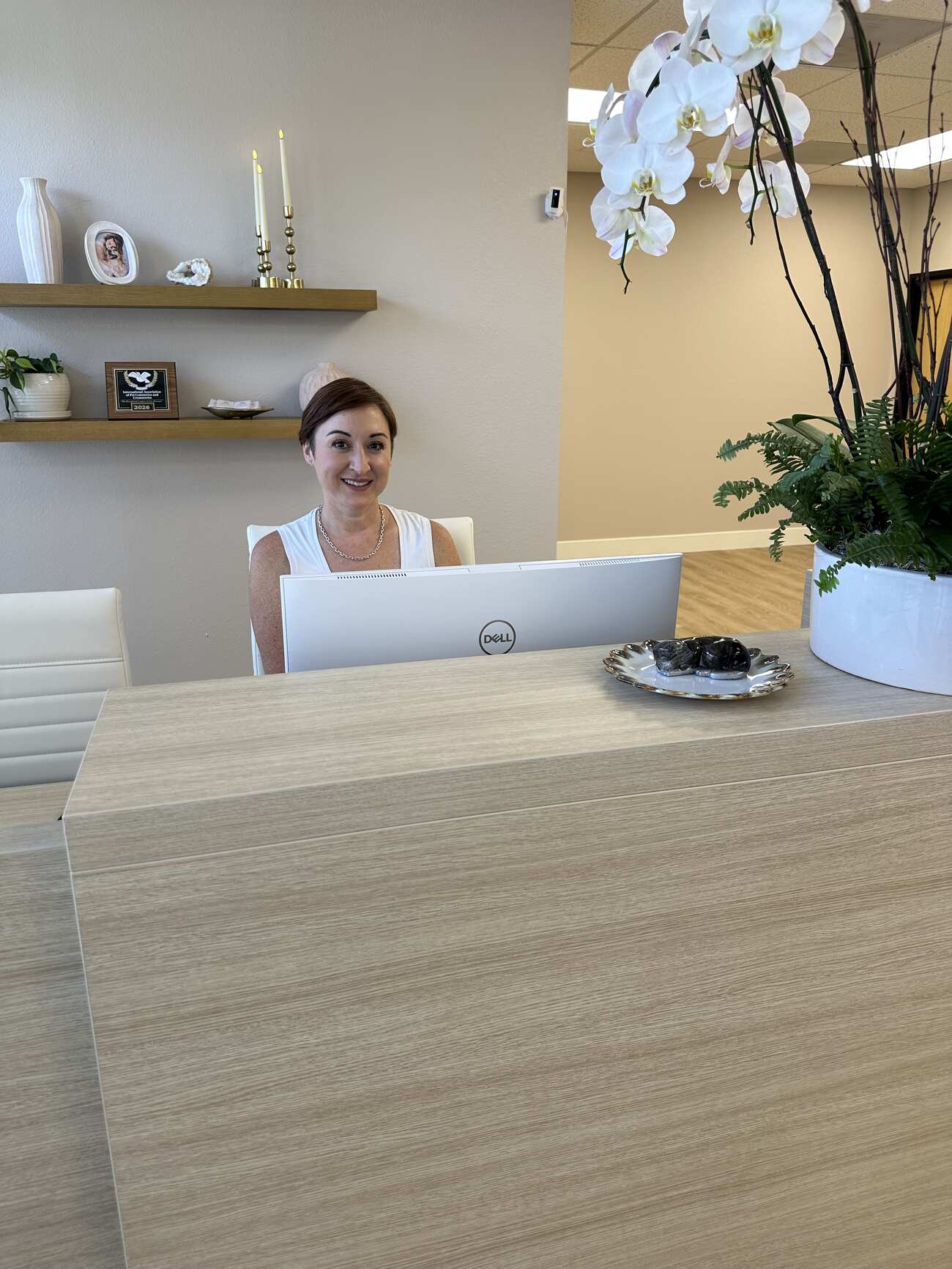 Woman seated behind a reception desk