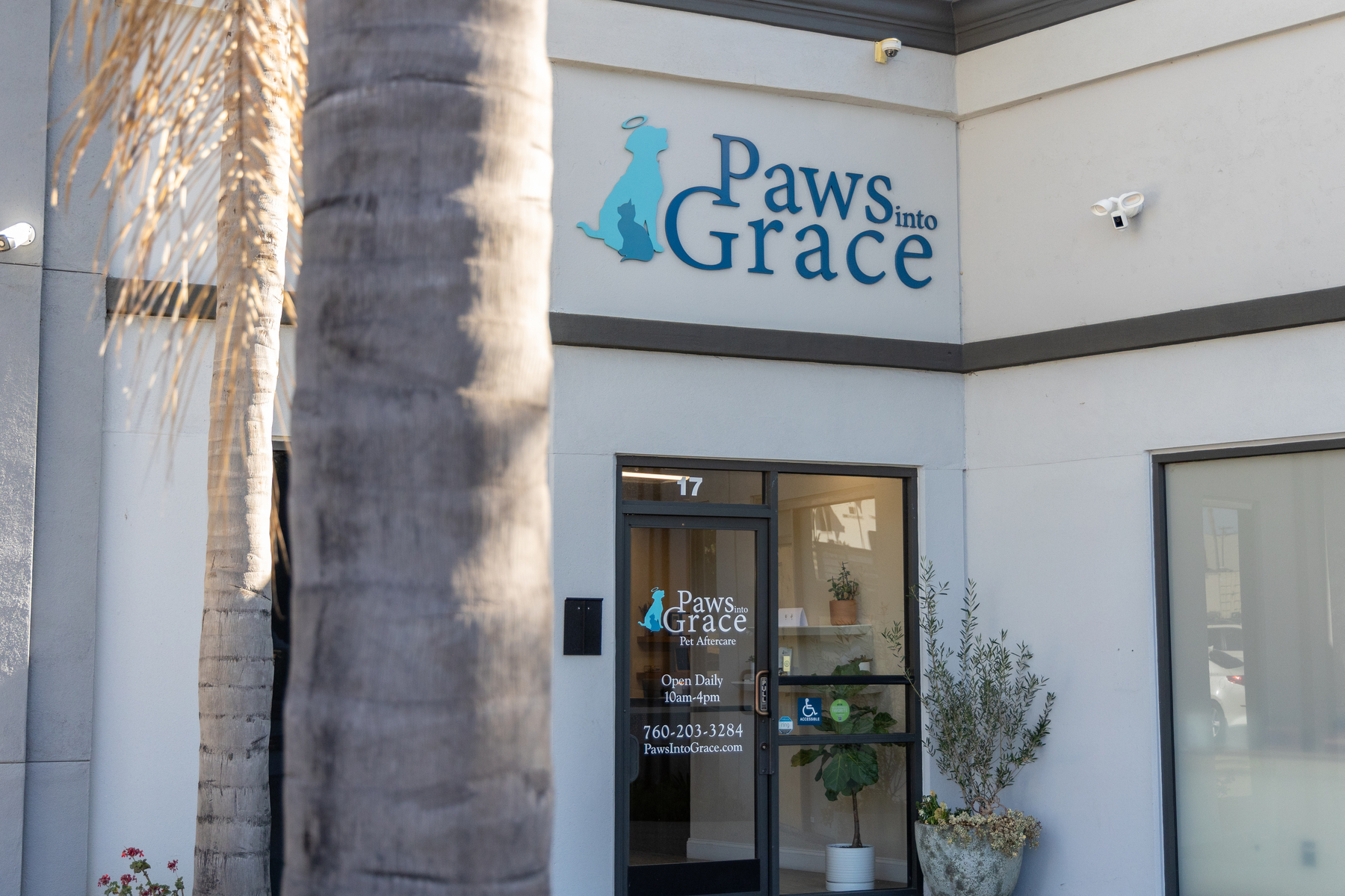 Exterior entrance of Paws into Grace pet aftercare facility with palm trees